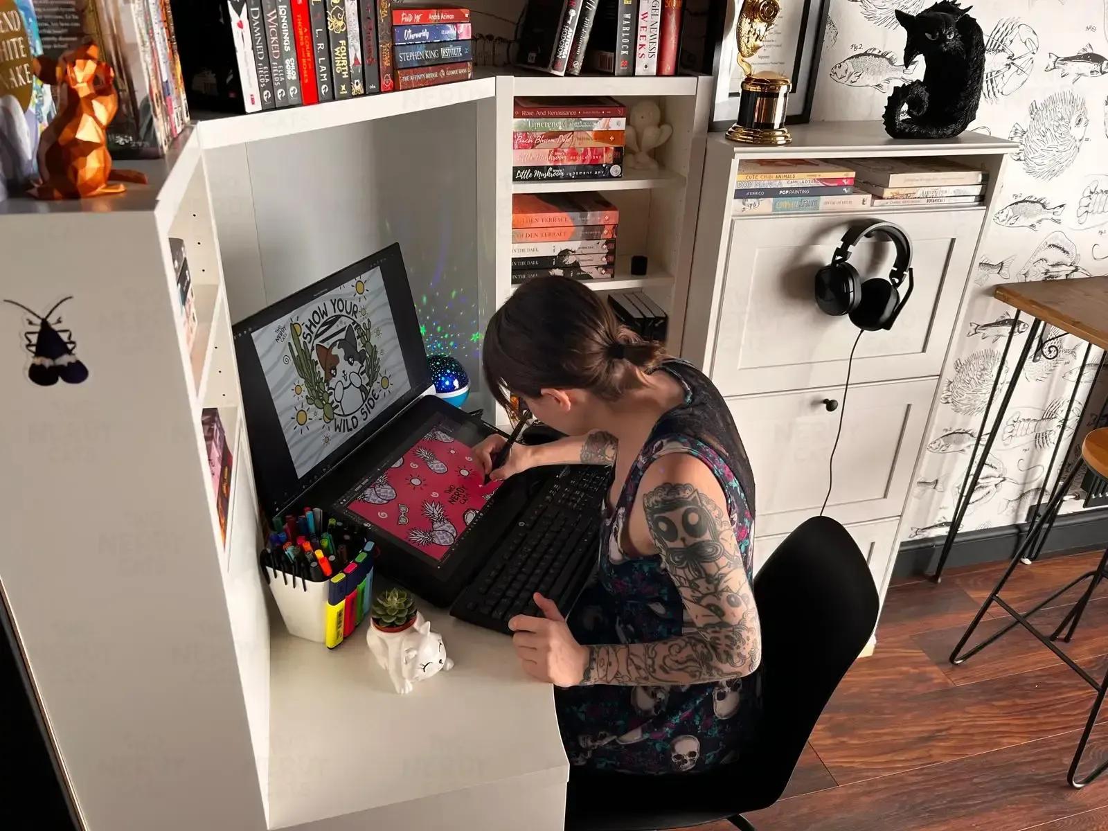 Two Nerdy Cats designer, Natalia, drawing on tablet in her workspace