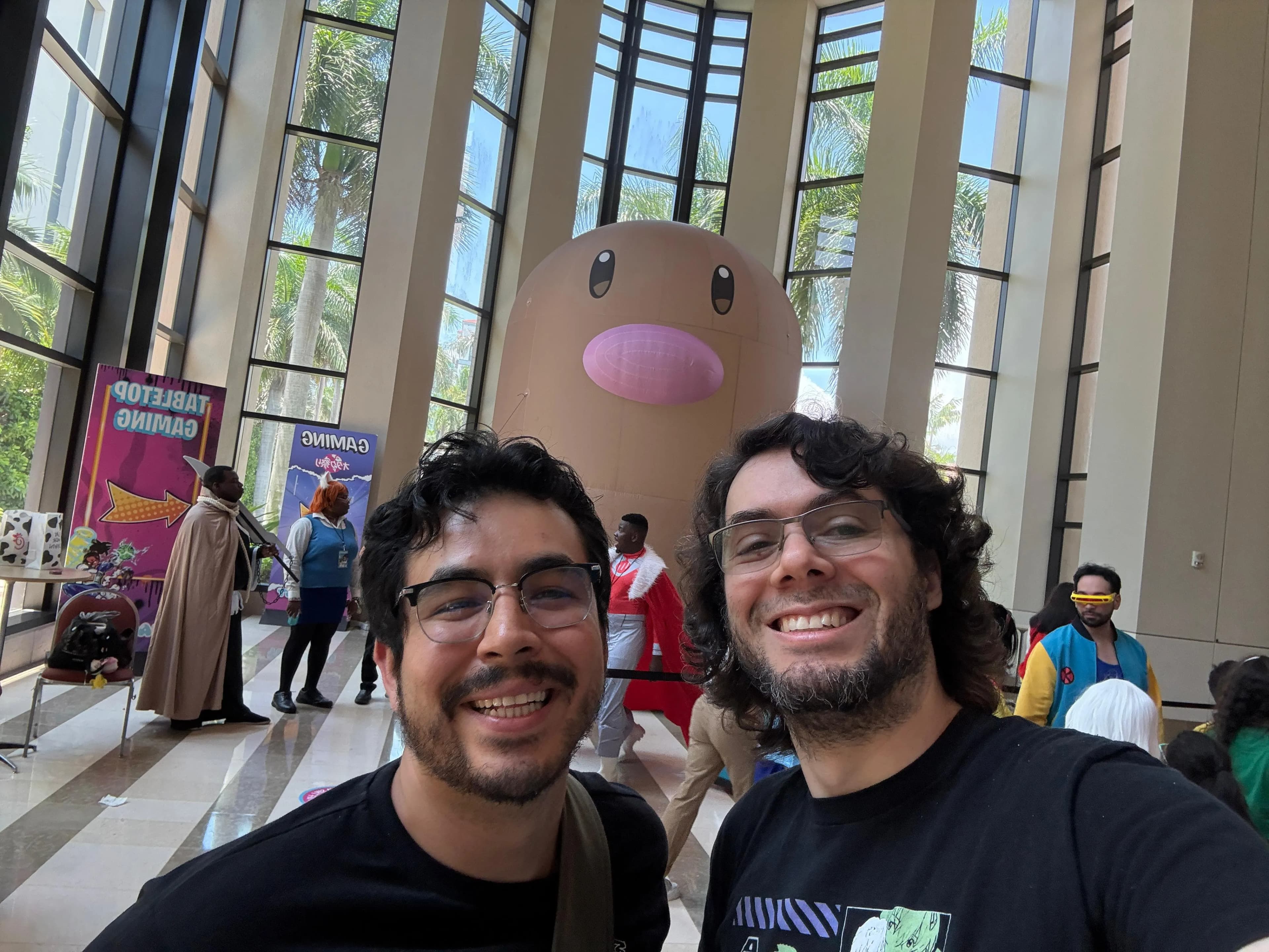 Two Nerdy Cats cofounder Donald and friend Sergio at Otakufest 2026 with Diglet inflatable