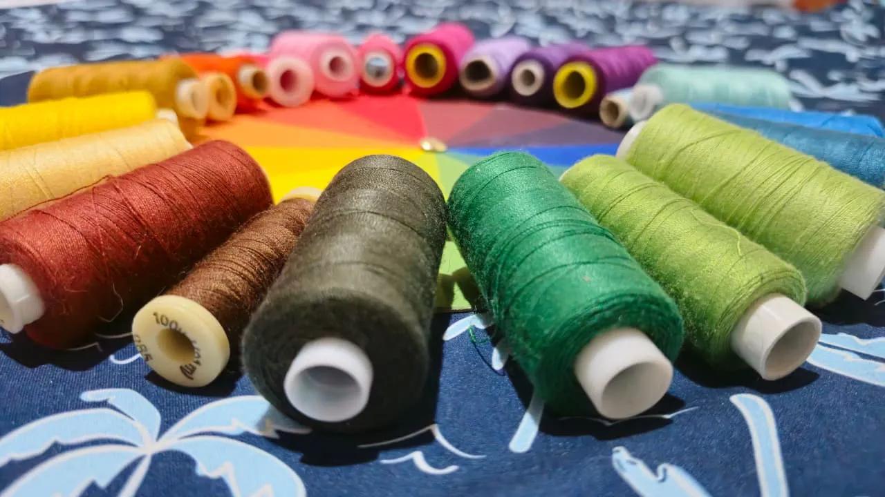 Color wheel surrounded by colorful spools of thread